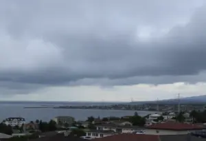 A view of Newport Beach under a dark sky symbolizing community mourning.
