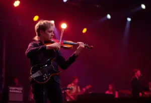 Electric violinist performing live in a spotlight